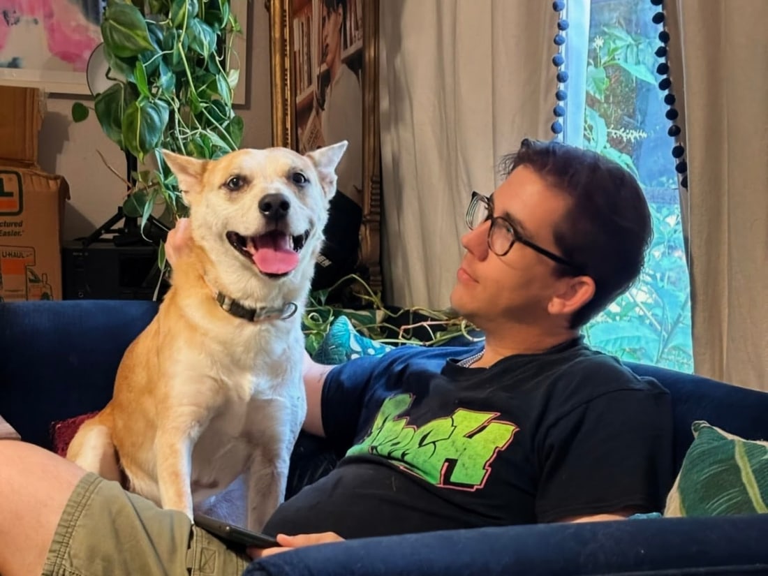 Brendon of Woof, Wag and Purr with a happy dog on the couch in South Austin