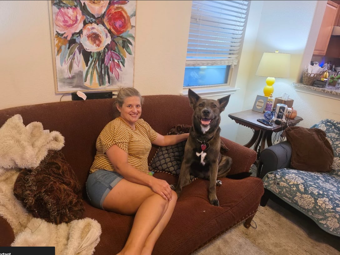 Laura of Woof, Wag and Purr relaxing with dogs she is caring for in their South Austin home